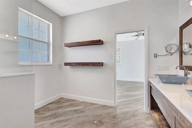 bathroom with vanity, wood finished floors, and baseboards