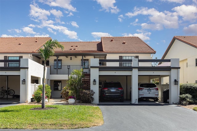 view of front facade featuring stucco siding, driveway, and a tile roof