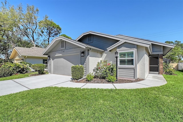 view of front of home featuring a front lawn, concrete driveway, a garage, and stucco siding