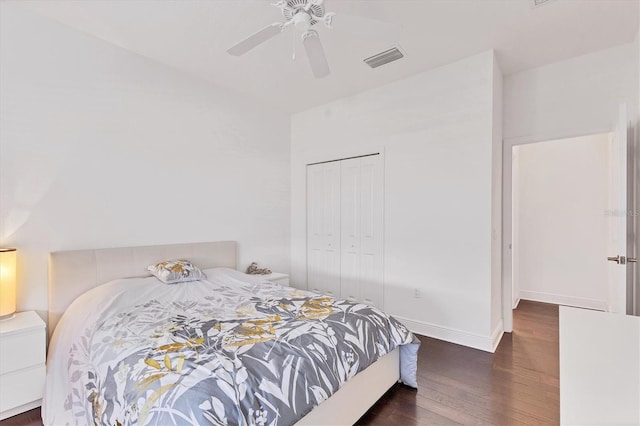 bedroom with visible vents, a ceiling fan, wood finished floors, a closet, and baseboards