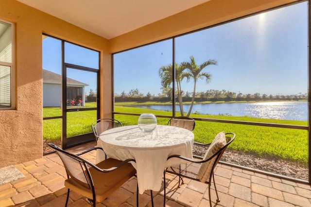 sunroom / solarium featuring a water view