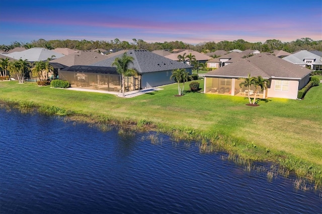 aerial view at dusk with a residential view and a water view