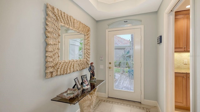 entryway with light tile patterned flooring and baseboards