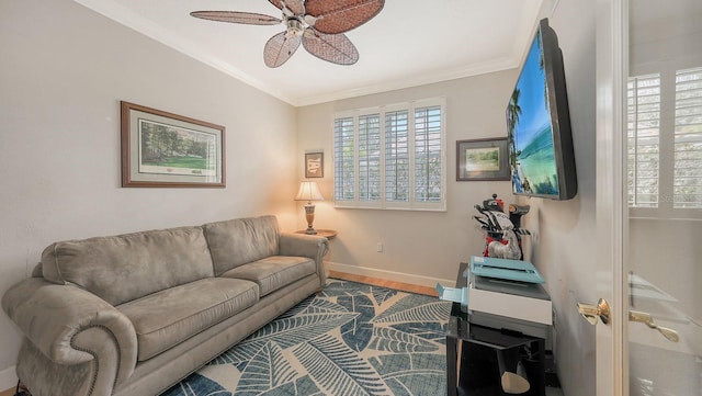 living room featuring crown molding, wood finished floors, baseboards, and ceiling fan