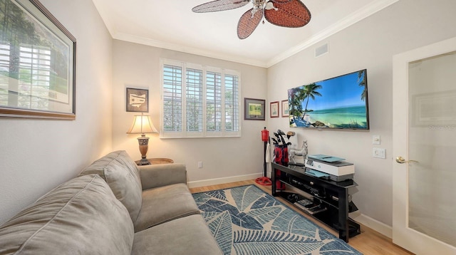 living room with visible vents, crown molding, ceiling fan, baseboards, and wood finished floors