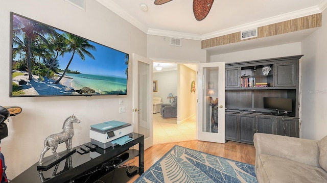 living area featuring visible vents, ceiling fan, french doors, crown molding, and light wood-type flooring