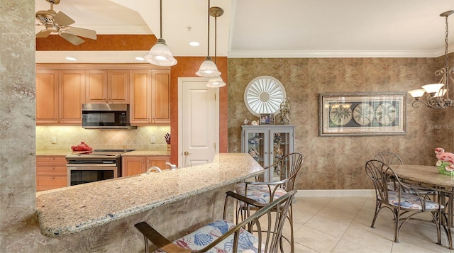 kitchen featuring light stone counters, baseboards, wallpapered walls, stainless steel appliances, and crown molding