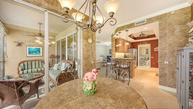 dining area featuring visible vents, a tray ceiling, ornamental molding, ceiling fan with notable chandelier, and light tile patterned flooring