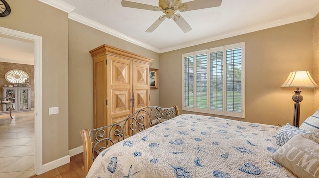 bedroom with crown molding, light tile patterned floors, a ceiling fan, and baseboards