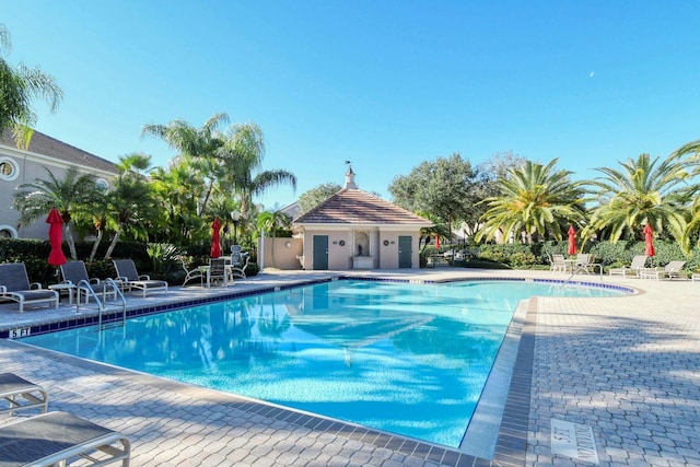 pool with a patio area and fence