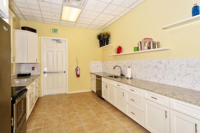 kitchen with open shelves, a sink, stainless steel appliances, white cabinets, and a paneled ceiling