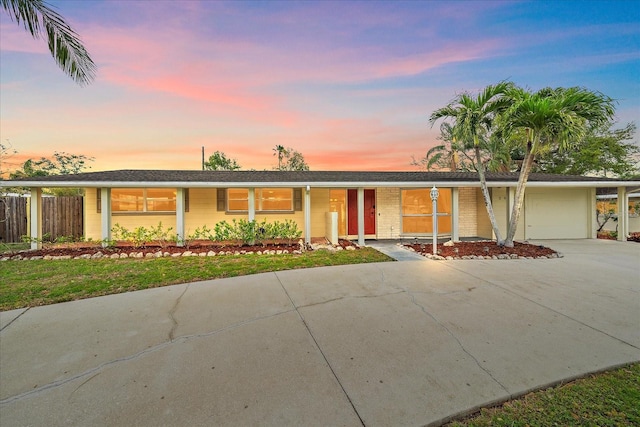 single story home featuring concrete driveway, a garage, and fence