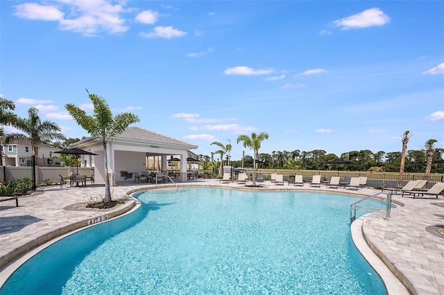 community pool featuring fence and a patio area