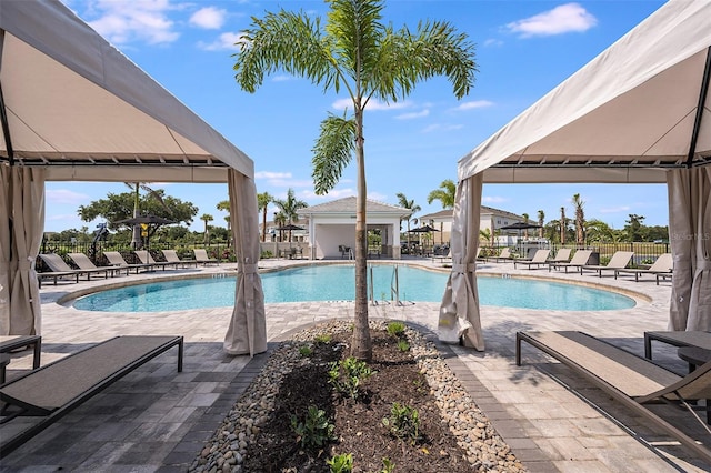 pool with a gazebo, a patio area, and fence