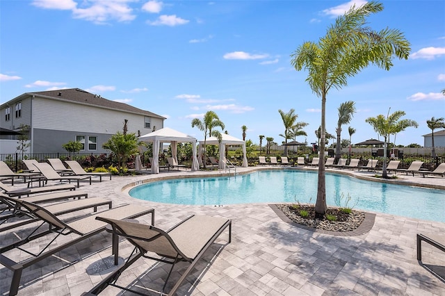 community pool featuring a gazebo, a patio, and fence