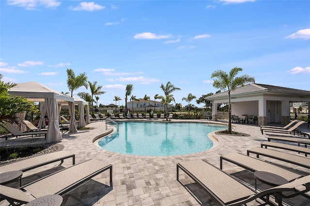 community pool with a gazebo, a patio, and fence