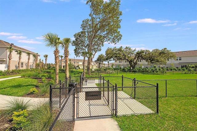 view of gate with a yard, a residential view, and fence