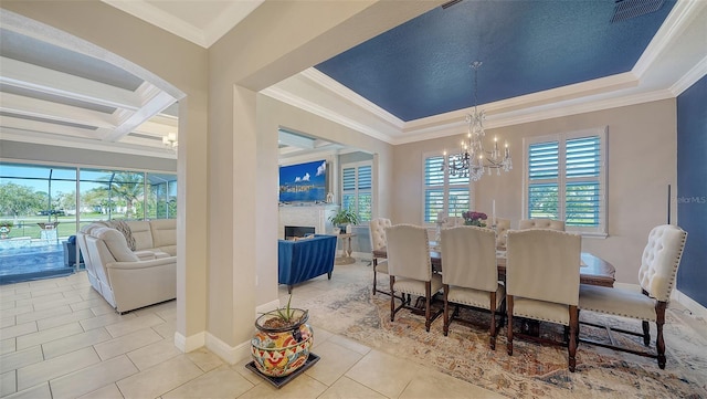 tiled dining space featuring visible vents, baseboards, ornamental molding, a fireplace, and an inviting chandelier