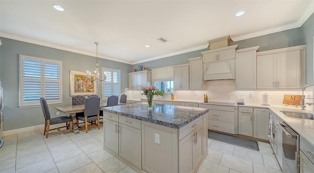 kitchen with visible vents, custom range hood, a sink, a center island, and dishwasher