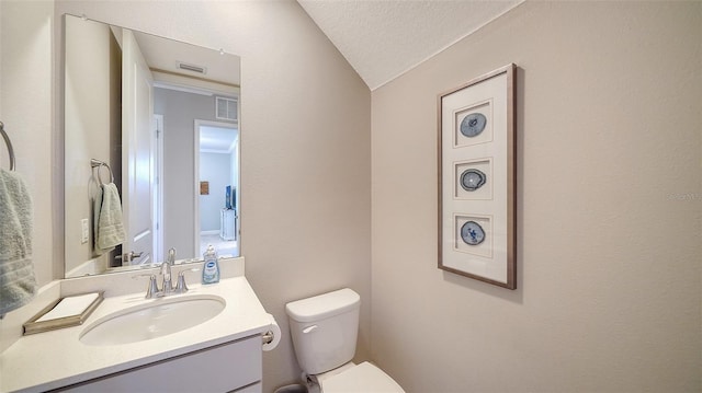 bathroom featuring visible vents, a textured ceiling, toilet, and vanity