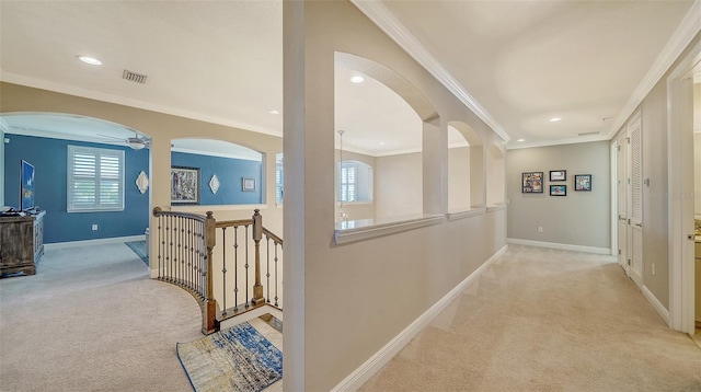 hall with an upstairs landing, light colored carpet, visible vents, and baseboards