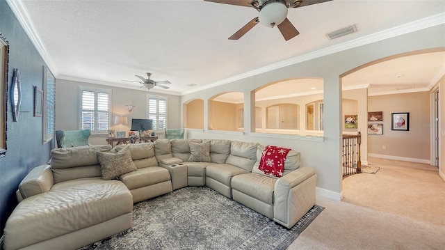 living area with visible vents, baseboards, light colored carpet, ornamental molding, and a textured ceiling