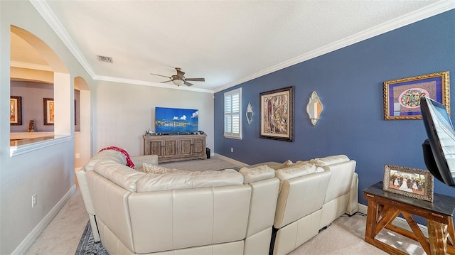 living room with ceiling fan, ornamental molding, visible vents, and light carpet