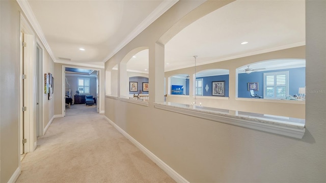 corridor with a healthy amount of sunlight, baseboards, carpet floors, and ornamental molding