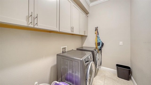 laundry room with light tile patterned floors, baseboards, cabinet space, ornamental molding, and washer and dryer