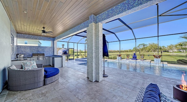 view of patio / terrace featuring glass enclosure, area for grilling, and an outdoor pool