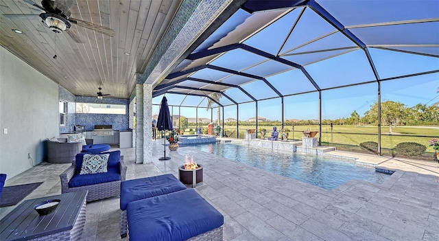 view of pool with a pool with connected hot tub, a patio, an outdoor kitchen, a grill, and a lanai