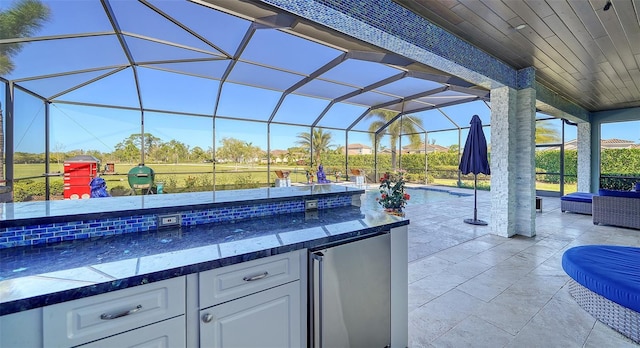 view of patio with a lanai, an outdoor kitchen, and an outdoor pool