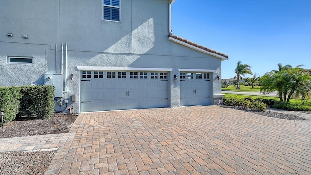 garage with decorative driveway