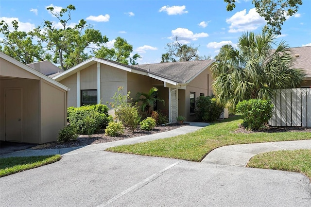 view of front of home featuring stucco siding and a front yard