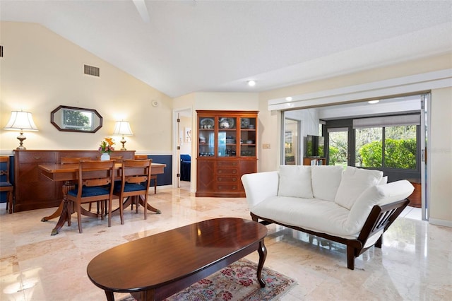 living area featuring visible vents, marble finish floor, baseboards, and lofted ceiling