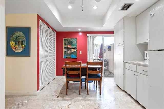 dining room featuring visible vents, baseboards, recessed lighting, a raised ceiling, and a ceiling fan