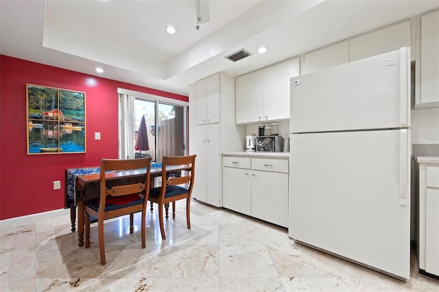 dining area with a tray ceiling, recessed lighting, visible vents, and baseboards