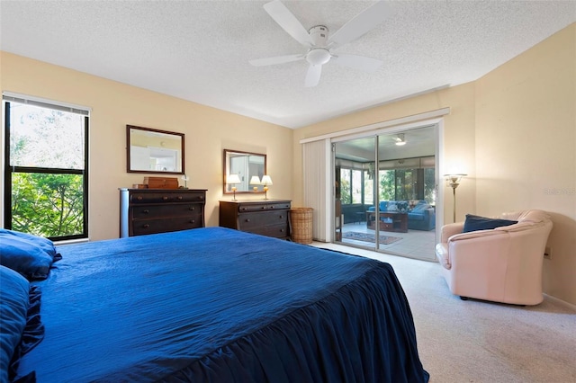 carpeted bedroom with a textured ceiling, ceiling fan, and access to outside