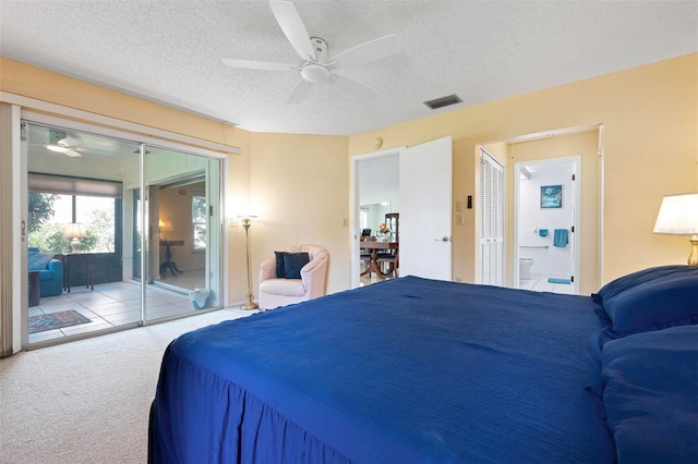 carpeted bedroom featuring visible vents, ensuite bathroom, a textured ceiling, a ceiling fan, and access to outside