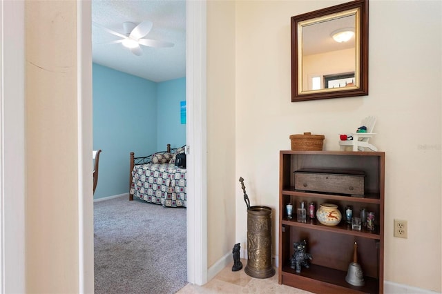 corridor featuring baseboards and carpet