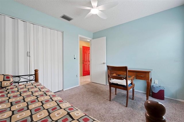 carpeted bedroom with visible vents, a textured ceiling, and ceiling fan