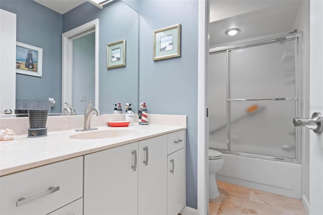 bathroom with vanity, toilet, tile patterned flooring, and shower / bath combination with glass door