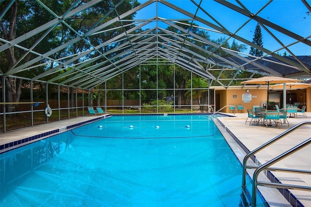 community pool featuring a patio area, glass enclosure, and fence