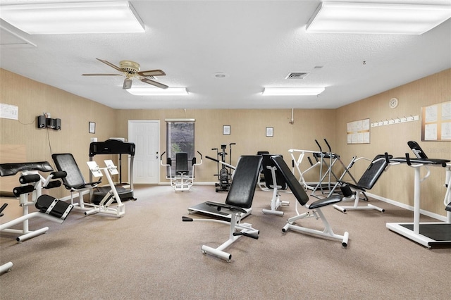 gym featuring visible vents, a textured ceiling, and a ceiling fan