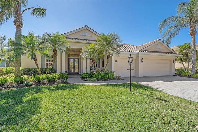 view of front of house featuring stucco siding, decorative driveway, french doors, a front yard, and a garage