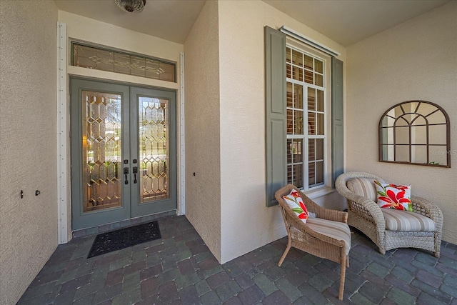 entrance to property featuring stucco siding and french doors