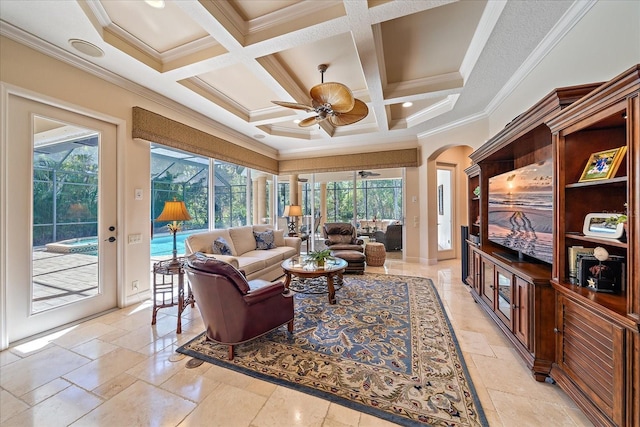 living area featuring crown molding, stone tile floors, a ceiling fan, and coffered ceiling