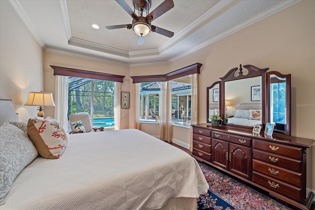 bedroom with a ceiling fan, baseboards, a tray ceiling, crown molding, and access to outside