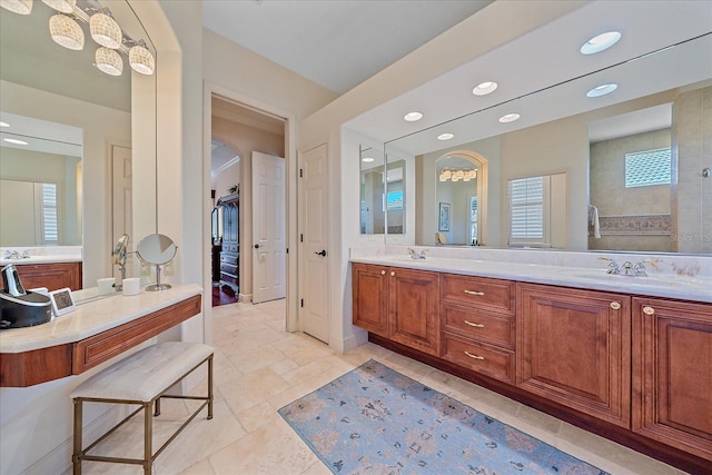 bathroom with double vanity, recessed lighting, walk in shower, and a sink