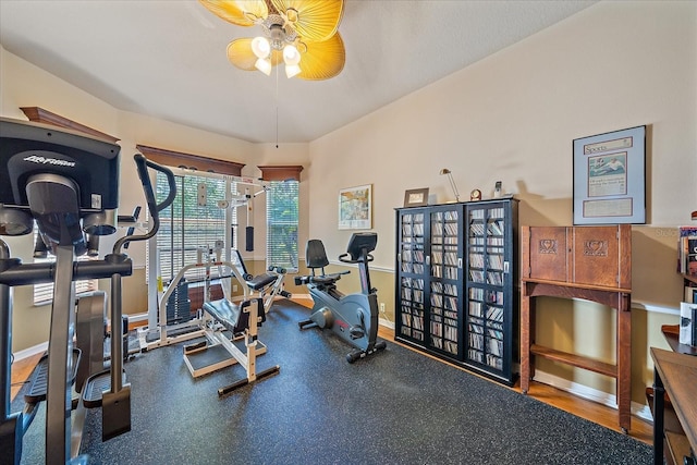 exercise area featuring ceiling fan and baseboards